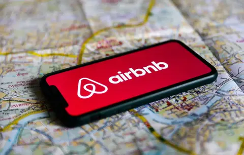 An Airbnb logo over a workspace, illustrating AI in software development